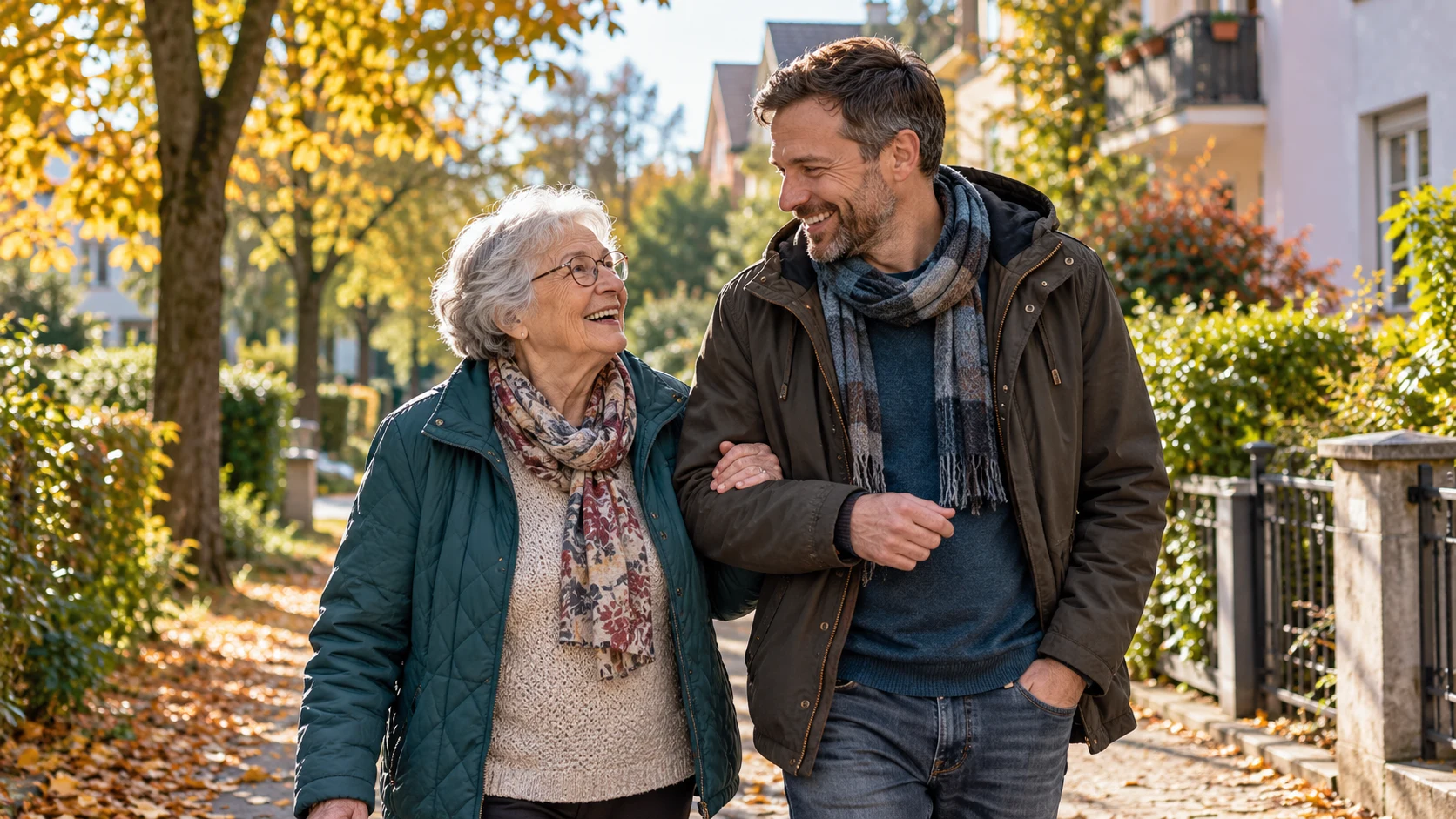 Eine Seniorin und ihr Begleiter gehen gemeinsam auf einem grünen Wohnweg spazieren